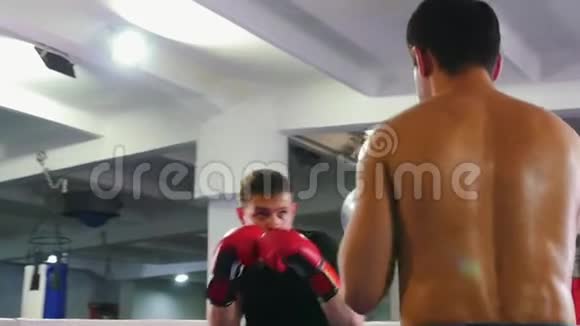 拳击训练两名男子在拳击场上进行激烈的战斗其中一名男子穿着黑色T恤视频的预览图