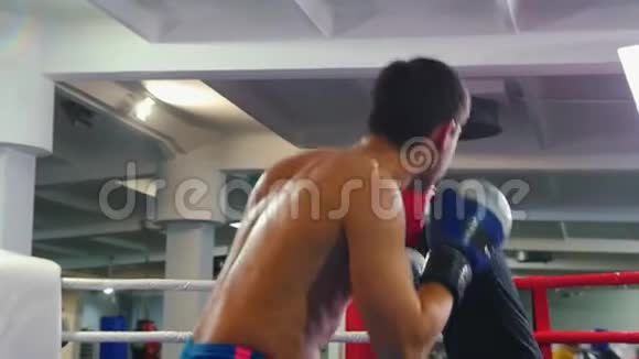 在室内进行拳击训练两名男子在拳击场上进行战斗其中一名男子穿着黑色T恤视频的预览图