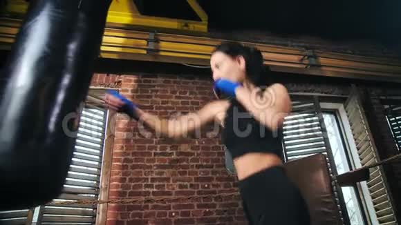 职业MMA战斗机苗条女孩完美的身体锻炼阁楼拳击工作室背景视频的预览图