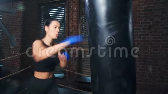 穿着紧身衣的亚洲女强人在盒装工作室练习拳击视频的预览图