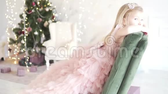 一个穿着华丽衣服的孩子疲倦地坐在椅子上等待新年和圣诞节的开始视频的预览图