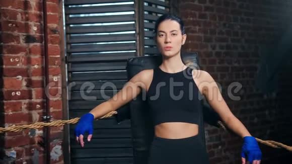 美丽的凶猛的亚洲女孩MMA战斗机摆在拳击场的角落里看着镜头视频的预览图