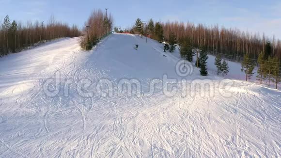 滑雪者在冬天的一天骑在山腰上俯视风景视频的预览图