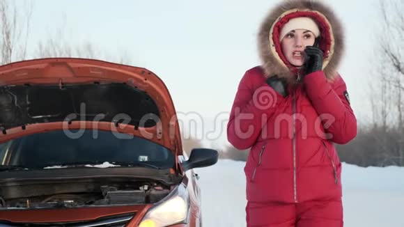 一个穿着红色冬装的女孩站在一辆破车旁边哭着视频的预览图