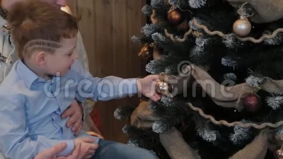 快乐的爸爸和小儿子在现代的室内装饰圣诞树视频的预览图