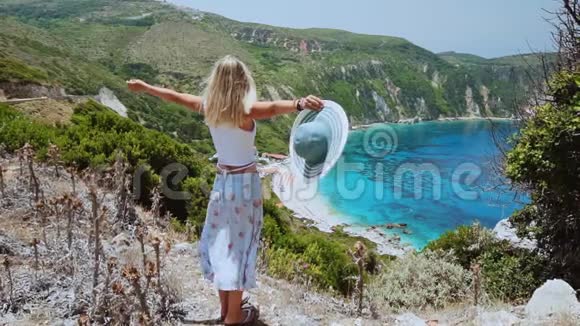 希腊凯法隆尼亚岛上一群金发美女手举太阳帽手举着手度假视频的预览图