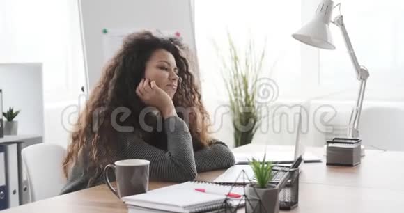 疲惫不堪的女商人在办公桌边工作关上笔记本电脑视频的预览图