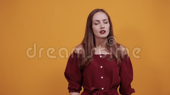 穿着栗色连衣裙的女人在工作室挥舞着双手因为温暖视频的预览图
