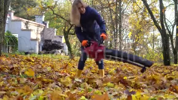技术熟练的园丁女人吹秋叶视频的预览图