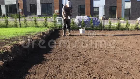 专业园林师在联排别墅院子里浇灌化肥视频的预览图