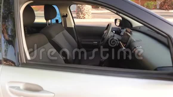 穿着蓝色连衣裙的女人坐在车里系好安全带开车前把钥匙放进点火器里视频的预览图
