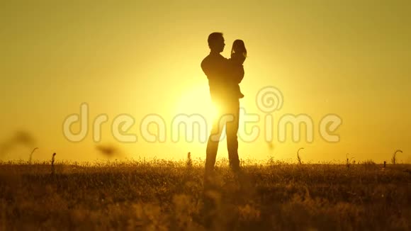 幸福童年的概念快乐的婴儿在日落时和他的父亲玩小女儿在教皇的怀里在阳光下视频的预览图