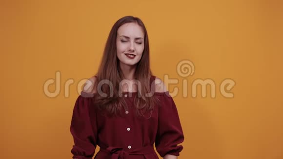 布鲁内特白种人女人穿着栗色连衣裙做摇滚手势享受音乐视频的预览图