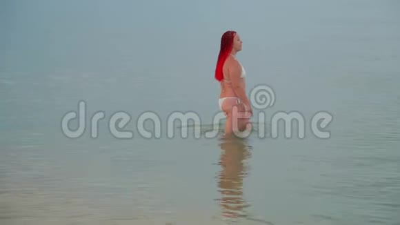 一个女人沿着海滨散步和洗澡视频的预览图