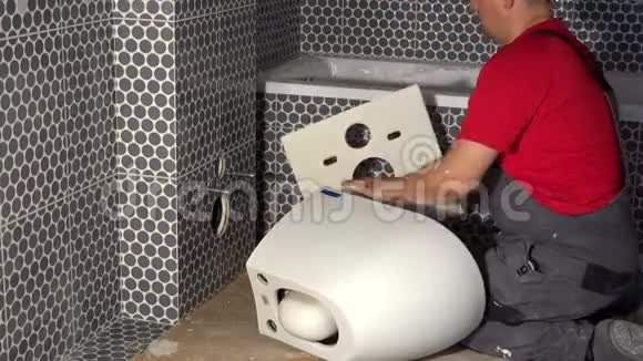 水管工在墙上加专用橡胶片准备挂马桶视频的预览图
