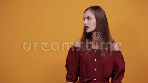 漂亮的白种人女人穿着栗色连衣裙指着一边困惑视频的预览图