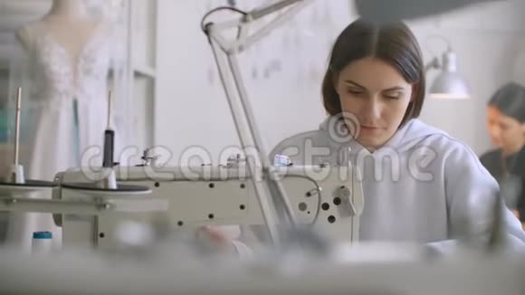 定制衣服缝纫工人在缝纫机上缝制衣服裁缝把衣服缝在衣服上视频的预览图