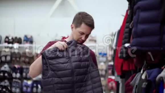 男士在服装店买羽绒背心视频的预览图