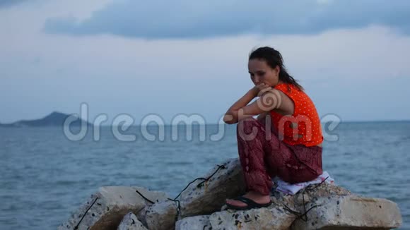 一个女人坐在石头上女孩又伤心又无聊视频的预览图