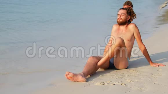 一个人在平静的大海附近的海滩上打太阳一个人享受阳光和孤独视频的预览图