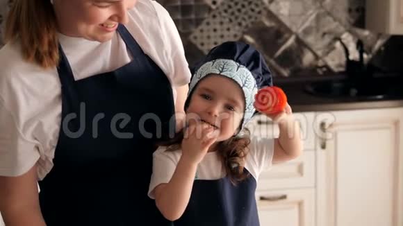 快乐的母亲和小可爱的女儿一起做饭在厨房里玩得很开心视频的预览图