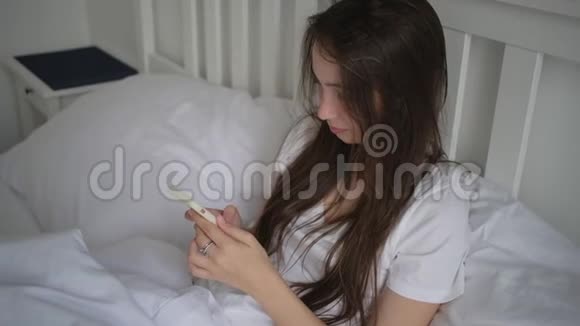 女青年休息日卧床休息使用手机视频的预览图
