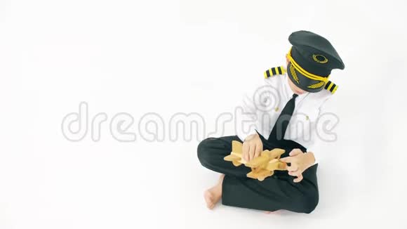 穿着飞行员制服男孩玩普通木制玩具飞机视频的预览图