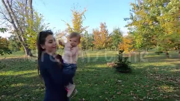 妈妈和女儿在秋天妈妈手上漂亮的十个月宝宝视频的预览图