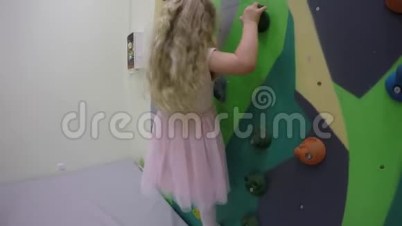 小女孩爬上室内攀岩墙视频的预览图
