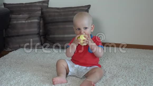可爱的小男孩吃去皮的苹果可爱的脸蛋小孩吃健康的水果视频的预览图