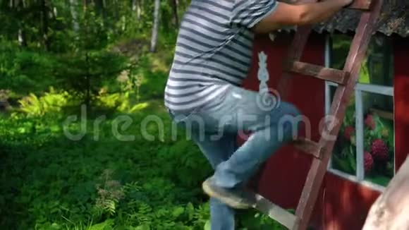 胖子在户外的高木梯上爬相机倾斜视频的预览图