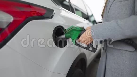 在加油站的一个特写镜头里女人往她的车里灌汽油视频的预览图
