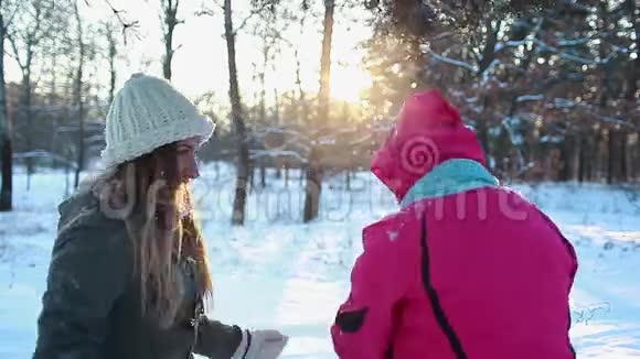女人在冬天的森林里用外套擦雪笑着家庭在户外玩得很开心视频的预览图