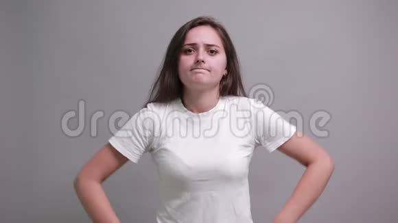 失望的黑发女郎穿着时尚的白衬衫双手捂着嘴视频的预览图