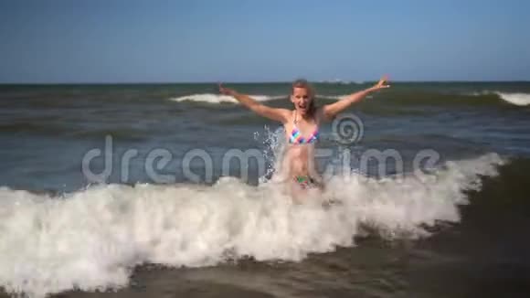 年轻健康迷人的女孩穿着色彩鲜艳的比基尼去海边冲浪美女视频的预览图
