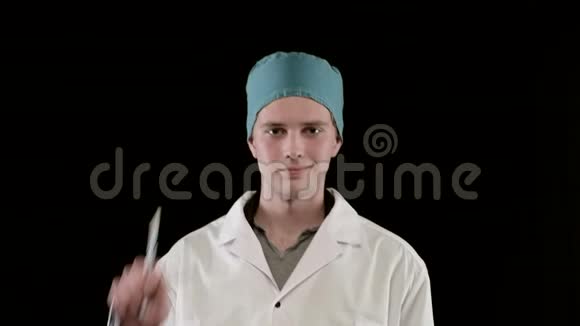 穿着医用外套的年轻人手上拿着两支注射器黑色背景特写视频的预览图