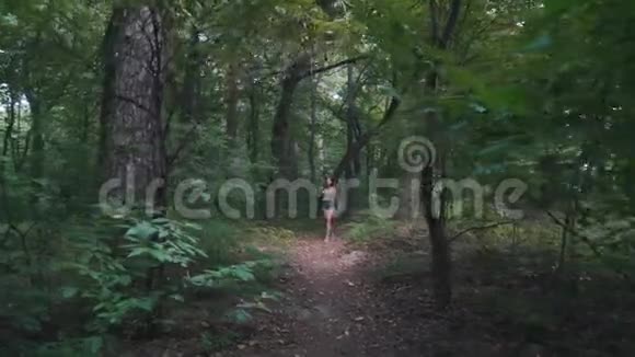 背着背包的女孩在树林里散步视频的预览图