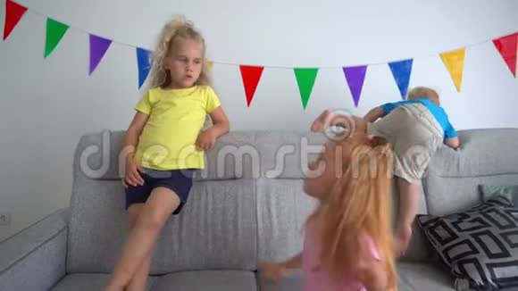 两个女孩姐妹和弟弟一起呆在沙发上视频的预览图