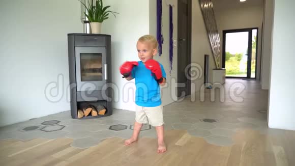 在家戴拳击手套的可爱男孩万向节运动视频的预览图