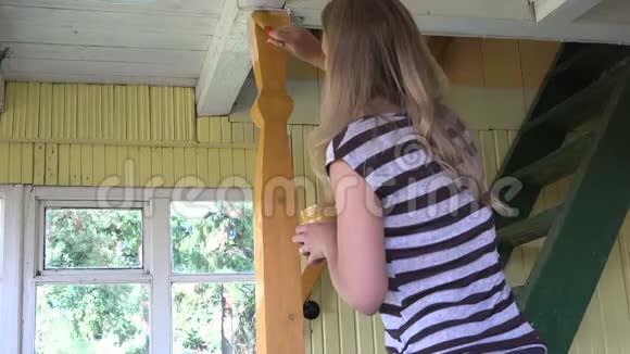 女画家在农家风前画木楼梯柱杆视频的预览图