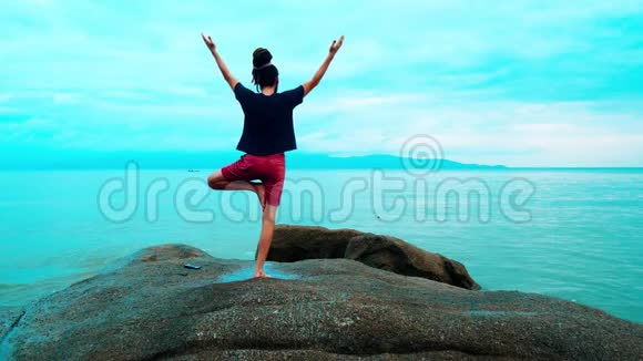 一个男人在海边的大石头上练习瑜伽视频的预览图