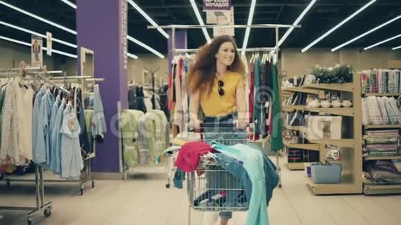 微笑的女士推着手推车沿着商店视频的预览图