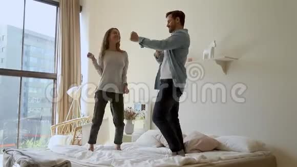 快乐有趣的年轻夫妇跳床垫舞视频的预览图