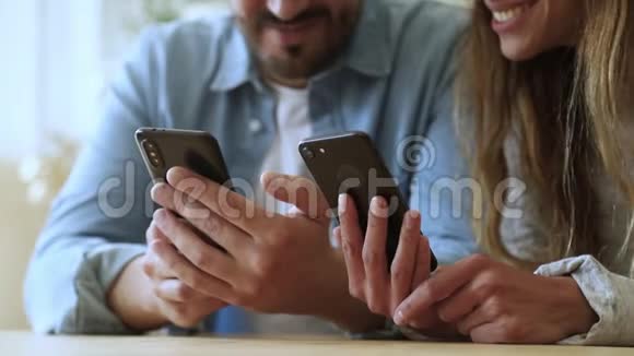 年轻夫妇使用智能手机应用程序谈笑风生近距离观看视频的预览图