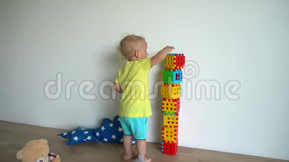 小心的男孩在家里用五颜六色的积木建造塔万向节运动视频的预览图