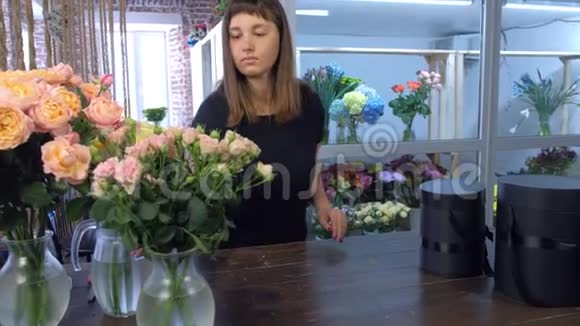 女花匠在花店里用不同种类的玫瑰做花束视频的预览图