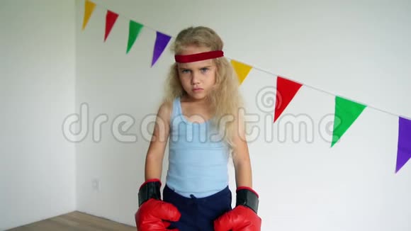 可爱的4岁女孩带着拳击手套儿童训练自卫视频的预览图