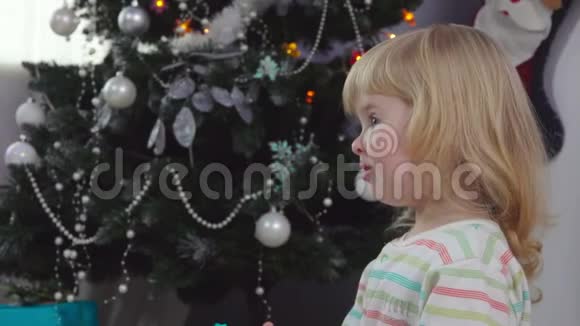 小可爱的女孩摇着圣诞礼盒视频的预览图