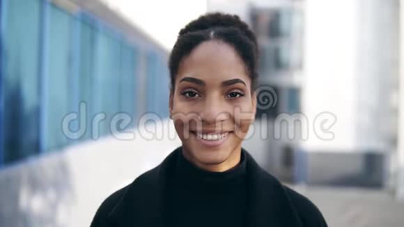 美丽时尚的非洲裔美国妇女的肖像微笑着看相机看上去自信穿着黑色衣服都市人视频的预览图