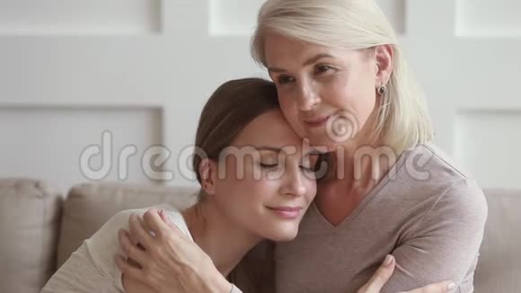 快乐成熟的母亲拥抱年轻的女儿享受温柔的时刻视频的预览图
